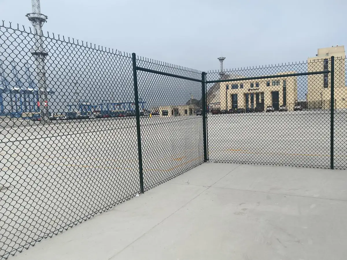 Green PVC-coated chain link fence with corner posts at the Chancay Port terminal